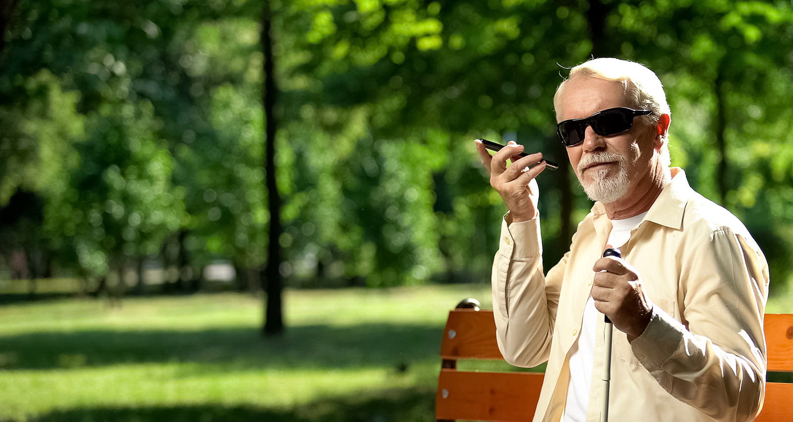 A visually impaired old man uses a voice control app in his smartphone