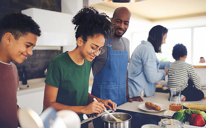 Father supervising his teenage kid when preparing food at home