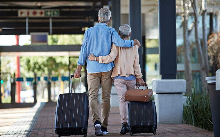 Couple walking with luggage at airport