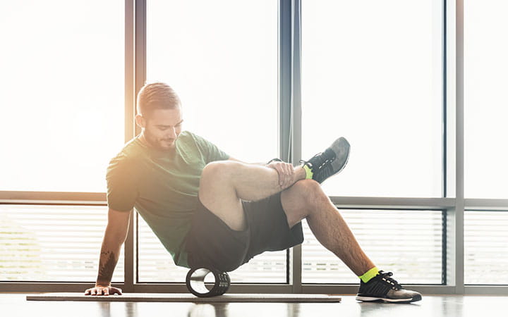 man exercising with rolling tube