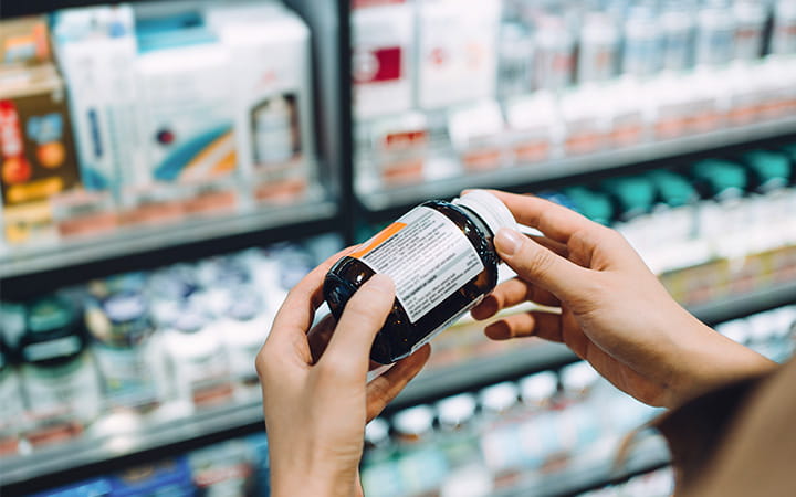 closeup of woman's hands holding a bottle of pills