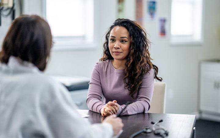Young woman talking with doctor