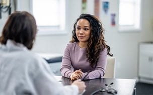 Young woman talking with doctor