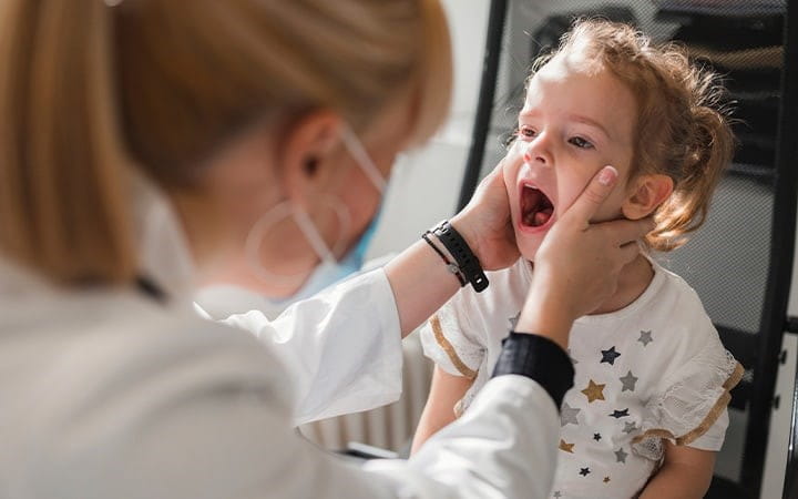 Doctor examines child's mouth