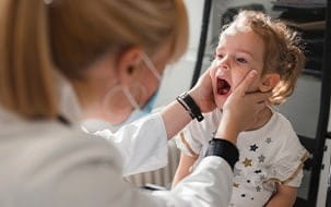 Doctor examines child's mouth