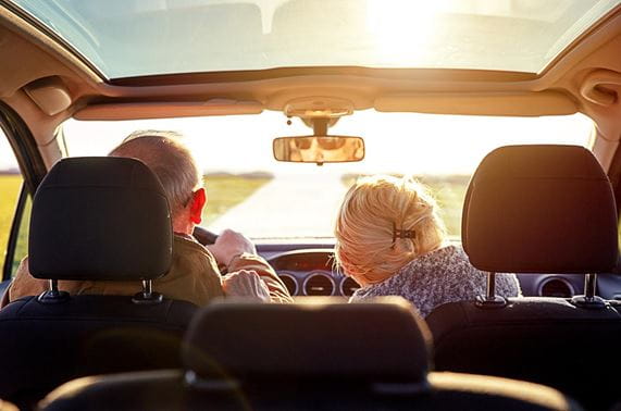 older couple in car on the open road