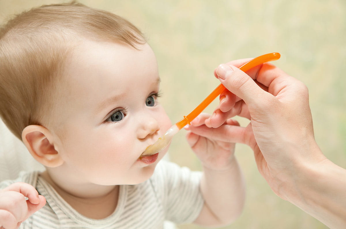Baby being fed from a jar