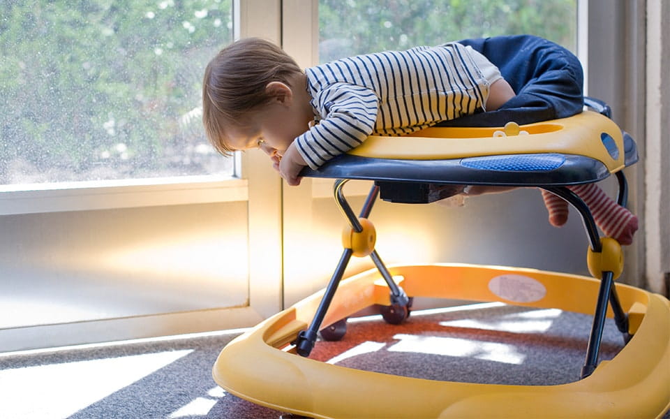 Infant peering over edge of baby walker