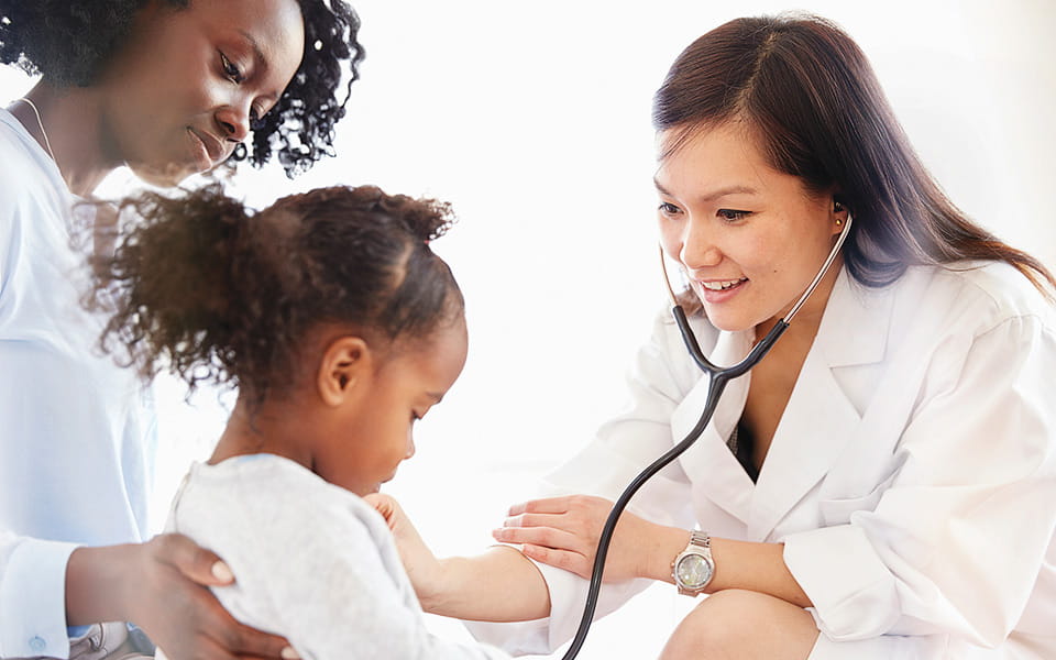 Doctor listening to girl with stethoscope