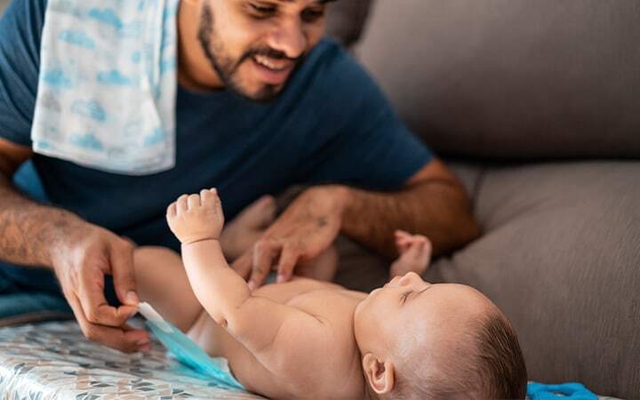 Father changes baby diaper