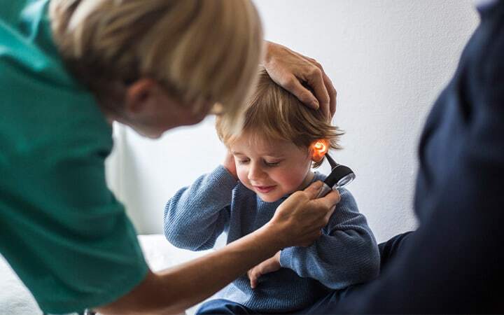 Doctor examines child's ear