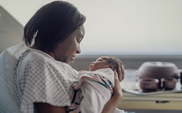Black mother holding newborn in hospital