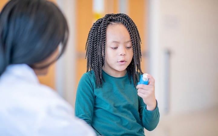 Small boy looking at his inhaler