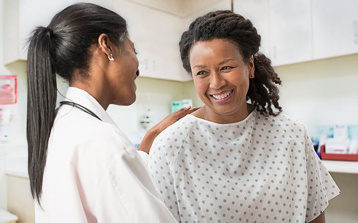 A doctor comforting her patient in her office
