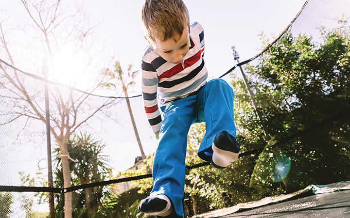 young boy jumping on trampoline