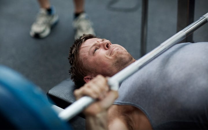 A man using the benchpress in a gym