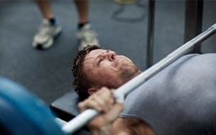 A man using the benchpress in a gym