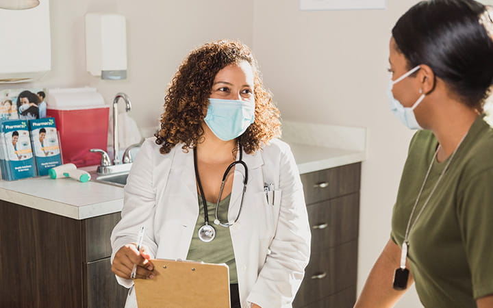 doctor in mask talking with young person