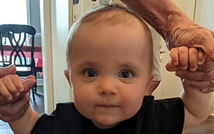 Young Vinny stands with a little help from family