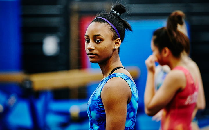 young female athlete with high balance beam
