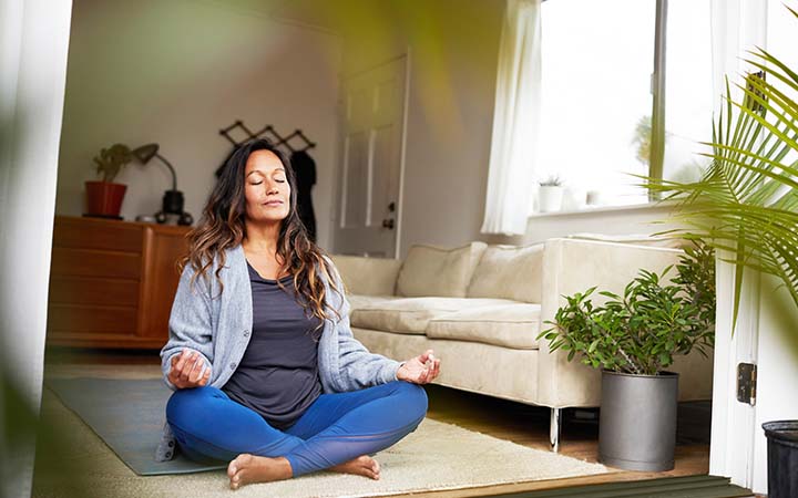 woman sitting cross-legged on the floor with hands on knees