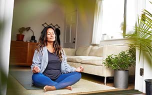 woman sitting cross-legged on the floor with hands on knees