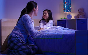 Mother talking with her child before bedtime, smiling