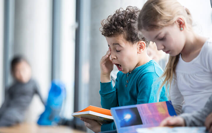 Boy yawning in school