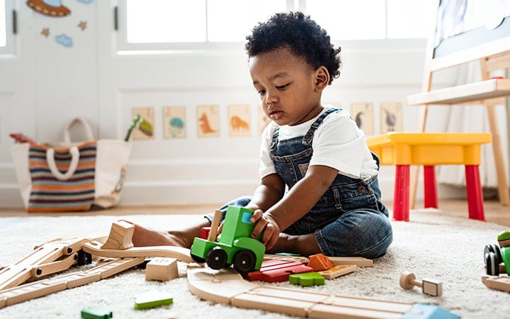 Cute little boy playing with a toy train