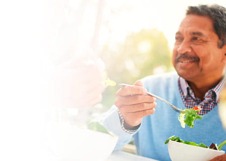 A happy older couple enjoying a healthy lunch together outdoors