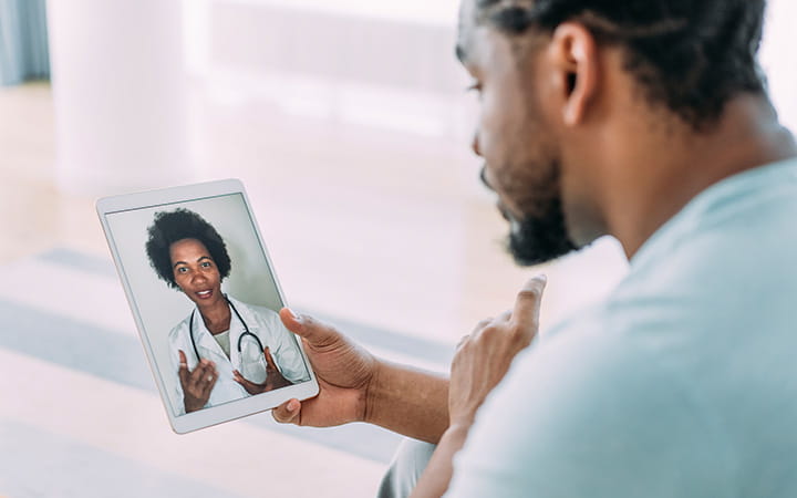 A patient talking to a doctor using digital tablet