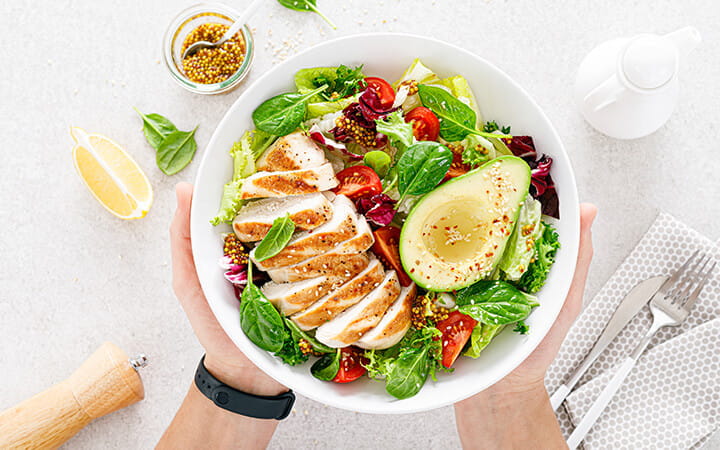 Grilled chicken and fresh vegetable salad of tomato, avocado, lettuce and spinach