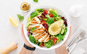 Grilled chicken and fresh vegetable salad of tomato, avocado, lettuce and spinach