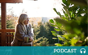 A happy senior woman with tea outdoors on terrace in autumn, relaxing