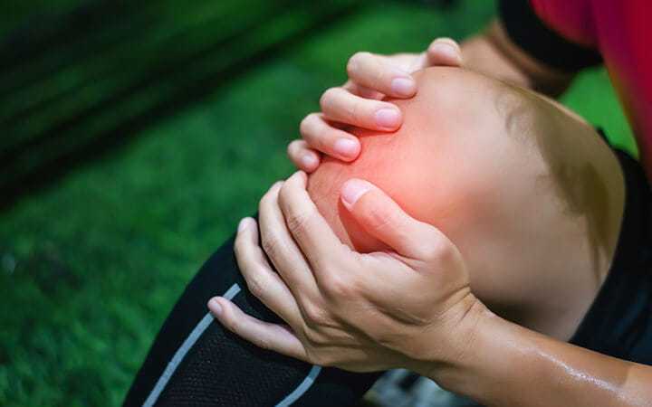 Male soccer player suffering from knee injury on field
