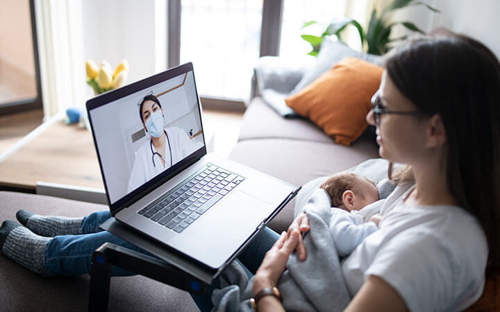 Mother and newborn baby at computer