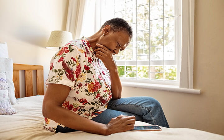Senior woman using phone in bedroom