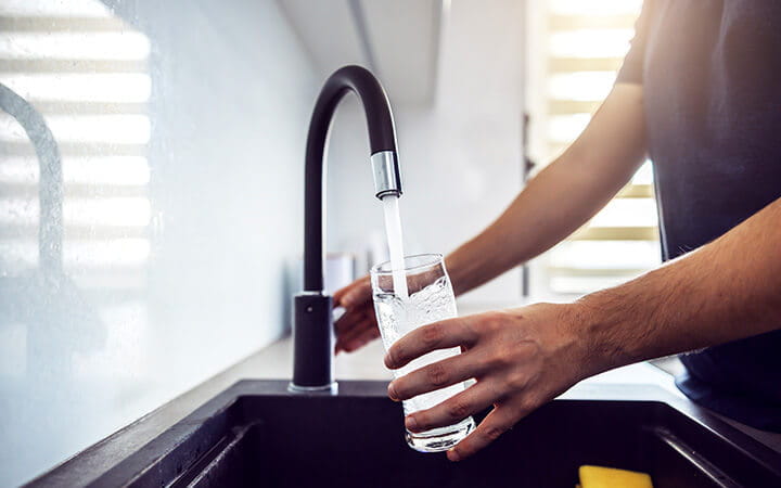 Young man pouring fresh water