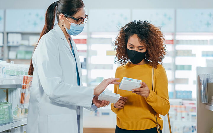 A professional pharmacist helping a female customer with medicine recommendation