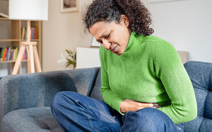 Woman in pain holding stomach