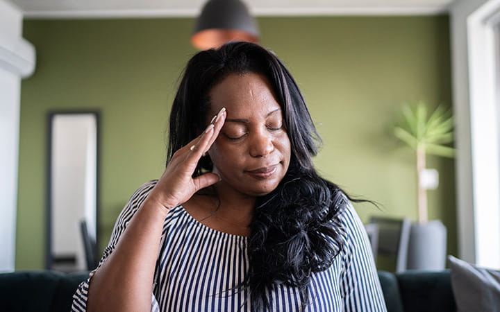 A mature woman with headache at home