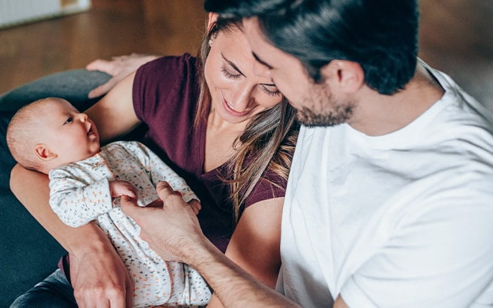 Man and woman hold newborn