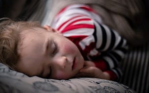 A little boy peacefully sleeping on a sofa