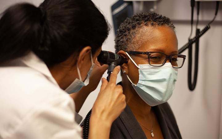 Doctor examining woman's ear