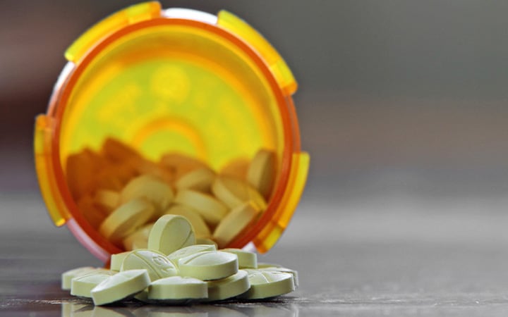 Pills spilling out of an open bottle