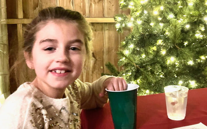 Ivy sits beside the Christmas tree