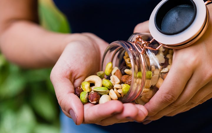 Woman pouring a variety of nuts into her hand