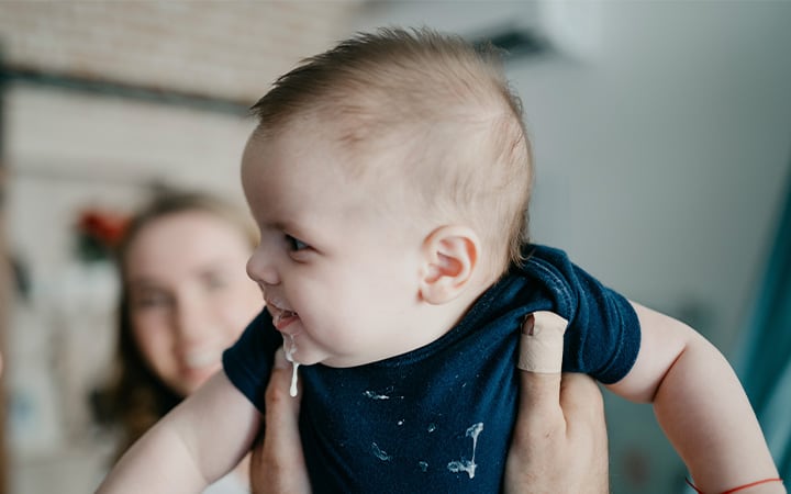 Baby boy dribbling milk