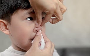 Mother caring for son's bloody nose