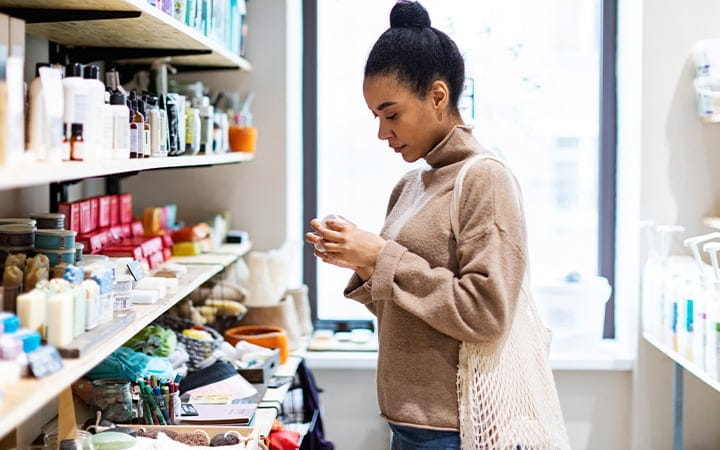 A young woman shopping for cosmetics in a zero waste store